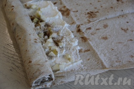 Немного подвернуть боковые края лаваша на начинку и свернуть лаваш в плотный рулет (у меня был очень длинный лаваш, поэтому я для формирования штруделя использовала только часть лаваша, смазанную начинкой, а чистую часть просто отрезала).