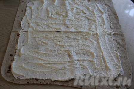 Лист лаваша смазать творожной начинкой, отступив от краёв по 2 см.