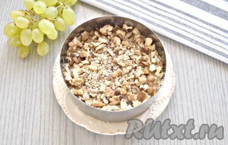 Очищенные грецкие орехи предварительно подсушиваем, периодически помешивая, на сухой горячей сковороде, даём им остыть. Орехи измельчаем ножом так, чтобы не превратить их в пыль, и выкладываем следующим слоем.