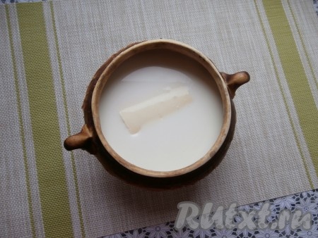 Залить рис молоком, поместить в горшочек сливочное масло и всыпать сахар, добавить ванильный сахар и щепотку соли, немного перемешать содержимое горшочка.