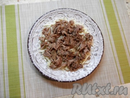 Затем выложить слой нарезанного мяса, поперчить его сверху по вкусу.