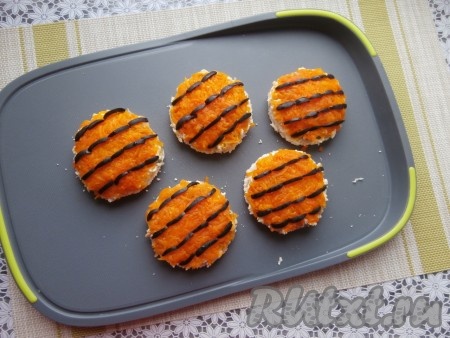 Чёрные маслины нарезать на тонкие полосочки и украсить ими верх бутербродов в виде полос шкуры тигра.