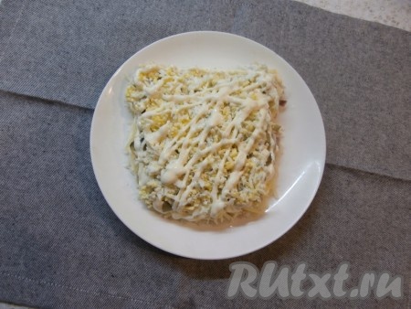 Далее яйца разделить на желтки и белки. Два белка отложить в сторону (они нам понадобятся для украшения). Оставшийся белок вместе с желтками натереть и выложить следующим слоем, смазать майонезом.