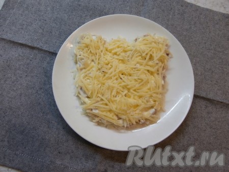 Следующим слоем выложить натёртый на средней тёрке сыр.