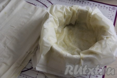 Вначале один лист теста фило выложить в форму для запекания масляным слоем вверх, края листа должны свисать с бортиков формы. На него выложить ещё 2 листа теста фило масляным слоем вверх, края этих листов тоже должны свисать с бортиков формы (как на фото). 