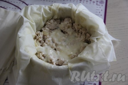 Яйцо соединить со сметаной и взбить венчиком (или вилкой) до однородного состояния. Половину получившейся смеси сметаны и яйца выложить на фарш.