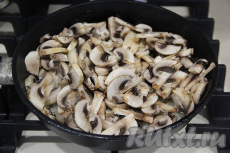 Шампиньоны промыть водой, нарезать на пластинки. Если вы готовите с отваренными лесными грибами, тогда крупные грибочки просто нарежьте на части. Подготовленные грибы выложить к обжаренному луку, перемешать.