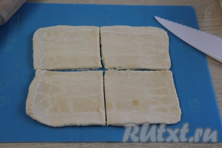 Каждый пласт слоёного теста на присыпанной мукой поверхности (или на силиконовом коврике) слегка раскатать скалкой и разрезать на 4 квадрата. В результате из двух пластов теста у меня получилось 8 квадратов.