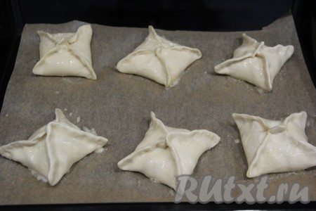 Яичный желток слегка перемешать вилкой. Смазать конвертики яичным желтком. Духовку разогреть, а затем поставить в неё противень со слойками.