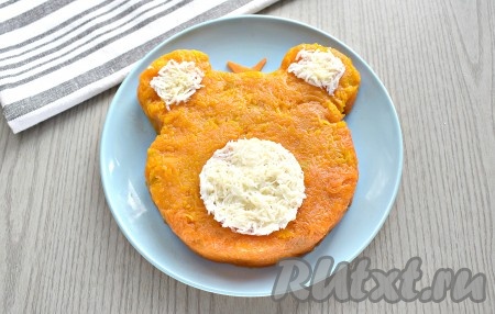 Из натёртого на мелкой (или средней) тёрке белка делаем мордочку и ушки.