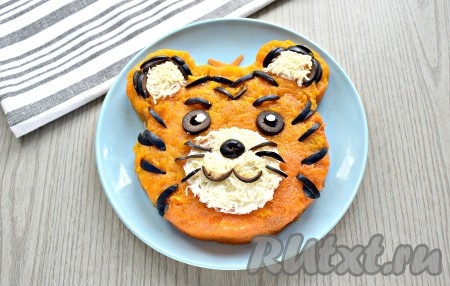 С помощью маслин "рисуем" глаза, чёрные полоски, усы и ротик тигрёнка. Ориентируйтесь на фото. Работа кропотливая, но результат того стоит. В восторге от такого кулинарного "шедевра" будут и взрослые, и дети.