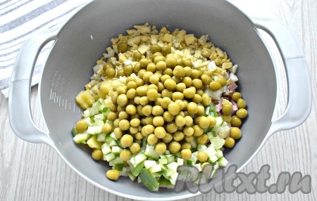 Зелёный консервированный горошек откидываем сначала на сито, а потом добавляем в миску к остальным ингредиентам. По традиции в салат нужно ещё нарезать морковь, но мы будем использовать её для оформления и в оливье не добавляем.