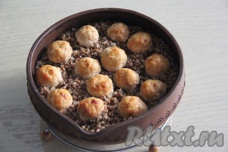 Накрыть форму с гречкой и фрикадельками фольгой, поставить в разогретую духовку и готовить при температуре 200 градусов 25 минут. Затем снять фольгу и запекать при той же температуре ещё 10 минут.