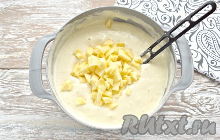 Яблоки очищаем от кожуры, удаляем семечки, нарезаем на маленькие кубики, перекладываем в тесто и ещё раз перемешиваем лопаточкой (или ложкой), аккуратно вмешивая яблоки в тесто.