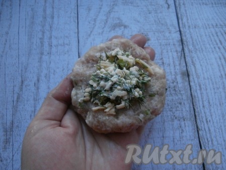 Сделать из фарша круглые лепёшки, внутрь которых поместить по столовой ложке сырной начинки.