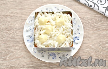 Разделяем яйца на белки и желтки. Сначала делаем слой из измельчённых белков (натираем их на тёрке). Этот слой можно чуть-чуть подсолить. Слой из белков смазываем майонезом.