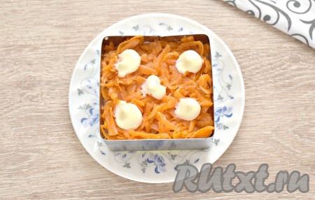 Следующим слоем выкладываем натёртую варёную морковку, смазываем майонезом.