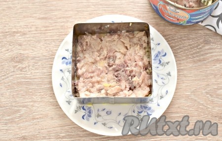 Кусочки консервированной горбуши сначала перекладываем из банки в небольшую тарелку и разминаем рыбу вилкой. Поверх картошки выкладываем равномерно слой рыбы, смазывать его не нужно.