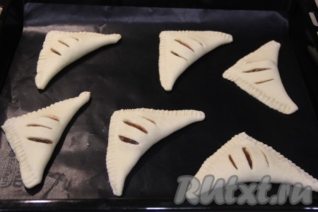 Противень застелить пергаментом (или тефлоновым ковриком) и выложить слойки на противень.