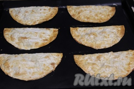 Поставить чебуреки в разогретую духовку и выпекать минут 20 при температуре 200 градусов.