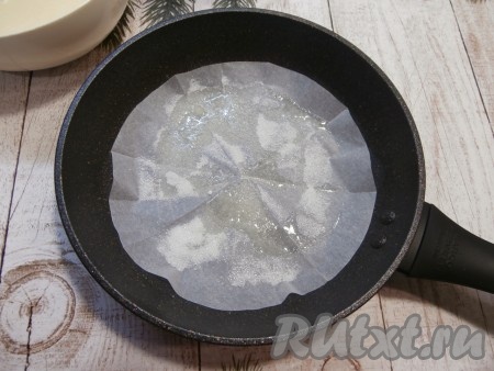 Дно сковороды с толстым дном застелить пергаментом. Смазать пергамент растительным маслом и посыпать 1 столовой ложкой сахара.