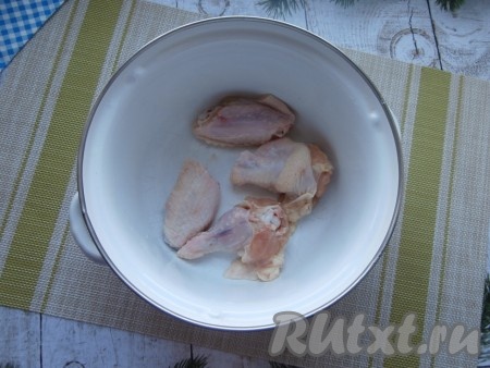 Куриные крылья разрезать на 2 части, поместить в кастрюлю.