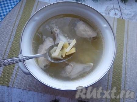 Налить в кастрюлю с куриными крылышками 2 литра воды, поставить на огонь, после закипания бульона убрать пену, посолить, уменьшить огонь и варить мясо 15 минут. Очистить картошку, лук и морковку. После того как крылышки с момента закипания проварятся 15 минут, выложить в кастрюлю картошку, нарезанную на кусочки, дать закипеть и варить минут 20-25 на медленном огне.