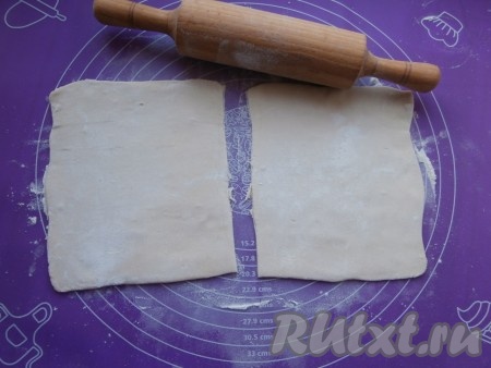 Пласт размороженного слоёного теста разрезать на 2 части (у нас получатся 2 хачапури). На присыпанной мукой поверхности раскатать каждую часть теста на квадраты размером 17 см х 17 см.