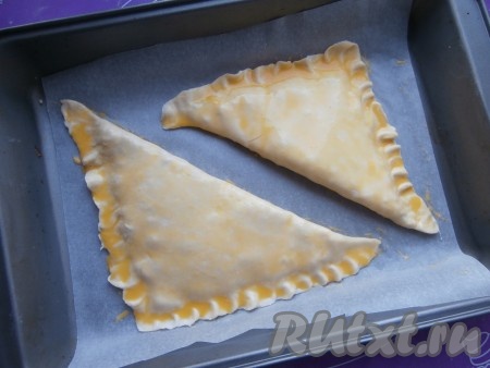 Выложить заготовки хачапури на противень, застеленный пергаментом. Хорошо смазать поверхность каждого хачапури взбитым желтком.