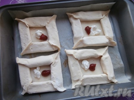 Смазать серединку заготовок кетчупом и сметаной.