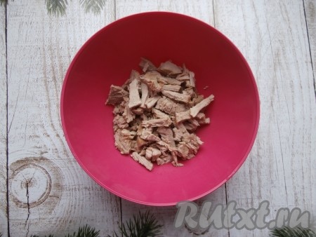 Мясо отварить в подсоленной воде. Я готовила салат со свининой, на её отваривание потребуется 40-50 минут с начала закипания воды, если будете готовить с мясом курицы, то его варите после закипания 25-30 минут. Варёное мясо остудить, нарезать длинными кусочками, выложить в миску.