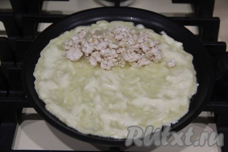 Сразу после того как кабачковый блинчик начнёт слегка "схватываться" сверху (как на фото), выложить ближе к одному краю блина 1 столовую ложку фарша с горкой.