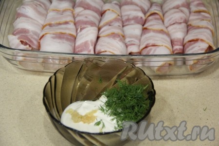 В отдельной глубокой тарелке соединить сметану, мелко нарубленную зелень (у меня - укроп) и пропущенные через пресс зубчики чеснока, тщательно перемешать.