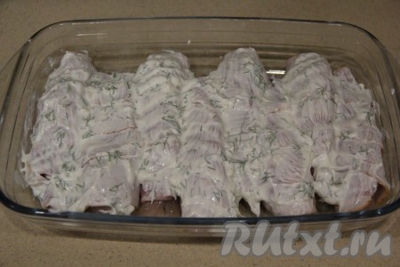 Смесью сметаны, чеснока и зелени смазать мясо в беконе.