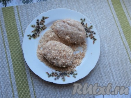 Сформировать влажными руками котлеты среднего размера, обвалять их со всех сторон в сухарях.