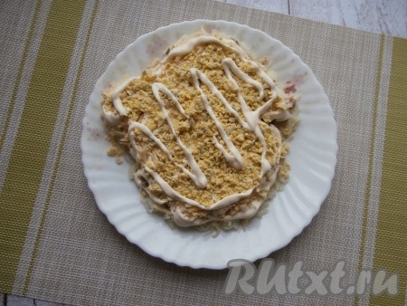 На рыбу выложить слой лука. Следующим слоем равномерно распределить натёртый сыр. Чуть смазать майонезом слой сыра. Желтки натереть на тёрке и выложить следующим слоем, нанести немного майонеза.