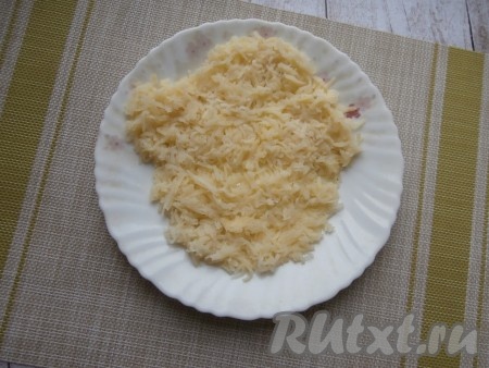 Отварной картофель очистить, натереть на средней тёрке и выложить его на плоскую тарелку первым слоем, формируя мордочку тигра. Картофельный слой сверху присолить.