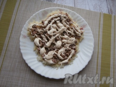 Сардины (лишнее масло лучше слить) выложить в отдельную тарелочку, хорошо размять вилкой, а затем выложить поверх картофеля. Щедро смазать слой рыбных консервов майонезом, поперчить.