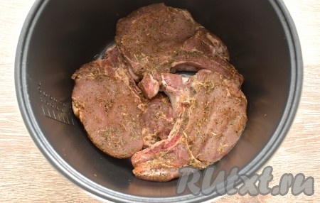 Вливаем растительное масло в съёмную чашу мультиварки, даём ему как следует прогреться. Затем выкладываем замаринованную свинину на кости в чашу в один слой.