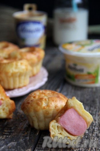 Подать вкусные, нежные и ароматные маффины с сосисками и сыром к столу.