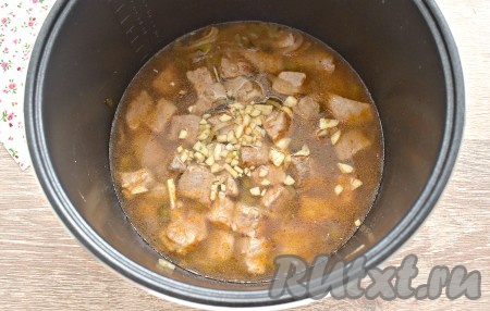 Очищаем зубчики чеснока, нарезаем их мелко и добавляем в чашу мультиварки, вливаем воду, перемешиваем. Мультиварку закрываем крышкой, включаем на 1,5 часа режим «Тушение».