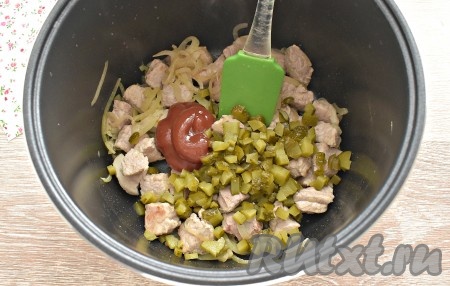 Затем к свинине с луком добавляем солёные огурцы, нарезанные на небольшие кубики, выкладываем томатную пасту, перемешиваем и обжариваем 5 минут, не закрывая мультиварку крышкой.