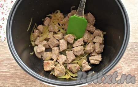 Вливаем растительное масло в съёмную чашу мультиварки, сюда же выкладываем полукольца лука и кусочки свинины. Включаем программу «Жарка». Периодически перемешивая, обжариваем лук со свининой 10 минут, крышку мультиварки не закрываем.