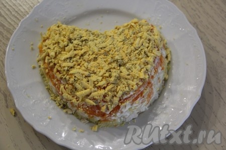 Почистить варёные яйца, разделить их на белки и желтки. Раскрошить яичные желтки и выложить их равномерно на морковку.