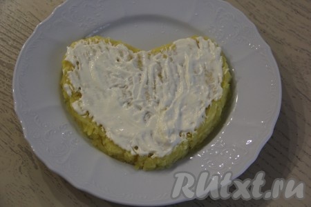 На картошку нанести слой майонеза, вилкой слегка разровнять и утрамбовать картошку.