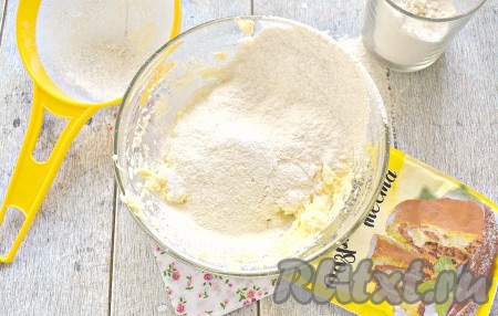 В получившейся массу просеиваем муку в 2-3 захода. Добавляя муку, сразу вмешиваем её в массу, сначала ложкой, а затем руками. Вместе с мукой добавьте разрыхлитель для теста.