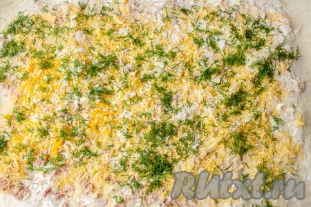 Промойте, обсушите и мелко нарежьте веточки укропа. Равномерно разложите укроп поверх яиц.