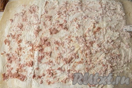 Из баночки с рыбой слейте лишнюю жидкость (эта жидкость нам в дальнейшем не потребуется), если нужно, рыбку разомните. Поверх лаваша, смазанного соусом, равномерно распределите кусочки консервированного тунца.