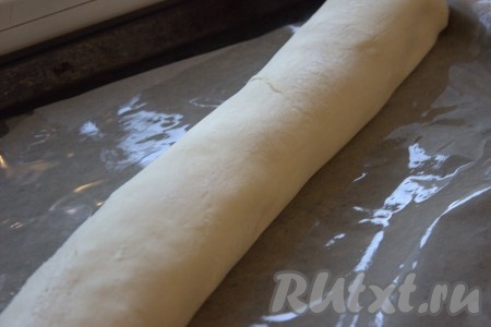 Свернуть слоёное тесто с начинкой в рулет, начиная с длинного края. Защипнуть края и подогнуть. Выложить пирог с картошкой и мясом на противень, застеленный пергаментной бумагой. Если пергамент не очень хорошего качества, то предварительно смажьте его растительным маслом.