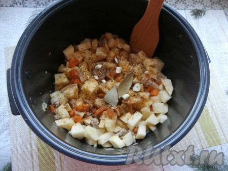 После того как фарш с овощами обжарится 10 минут, добавить в чашу картофель, приправы, специи, лавровые листья, нарезанный чеснок, соль, влить воду, крышку мультиварки закрыть.